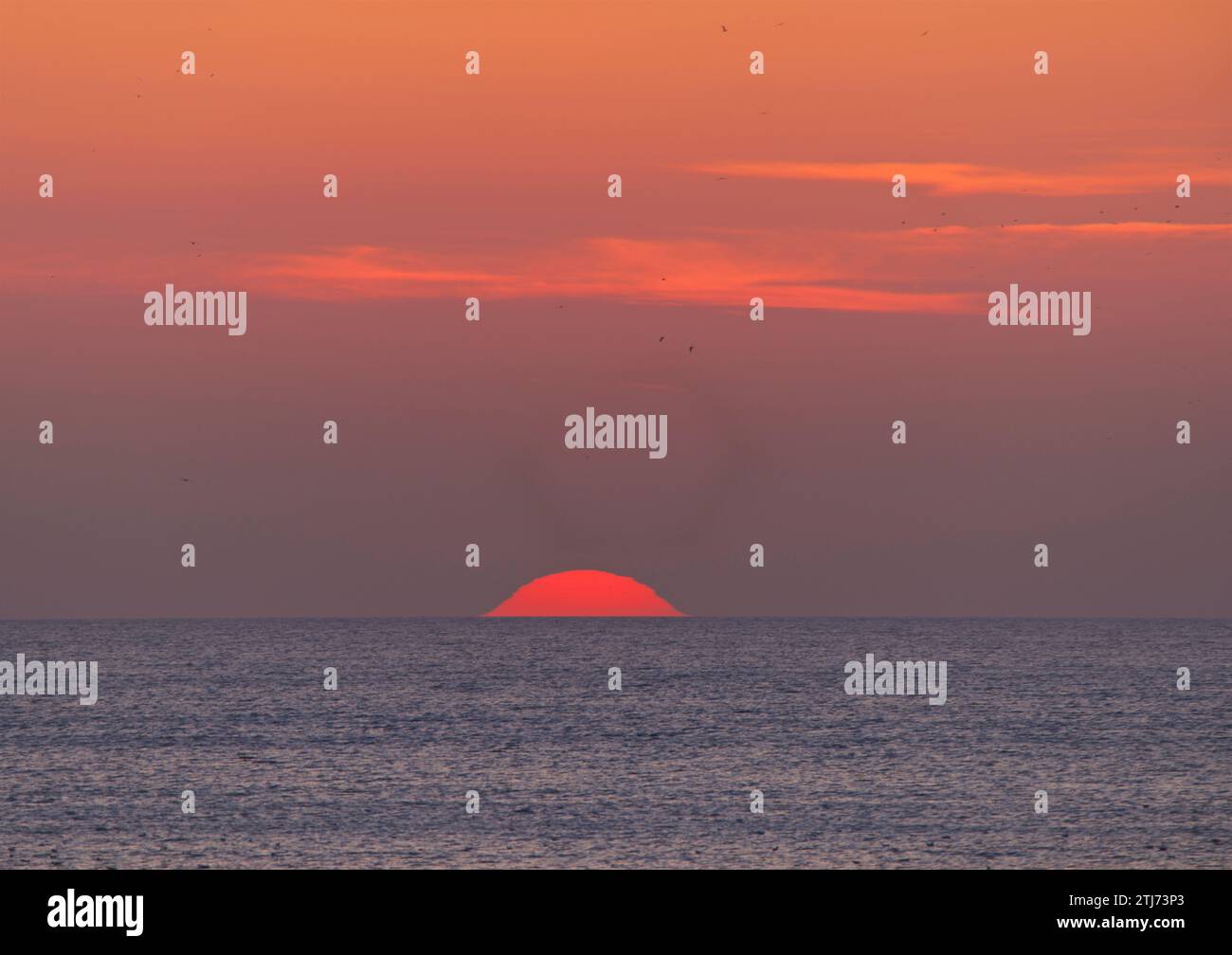 The Setting sun. A red/orange disc in the sky. Stock Photo