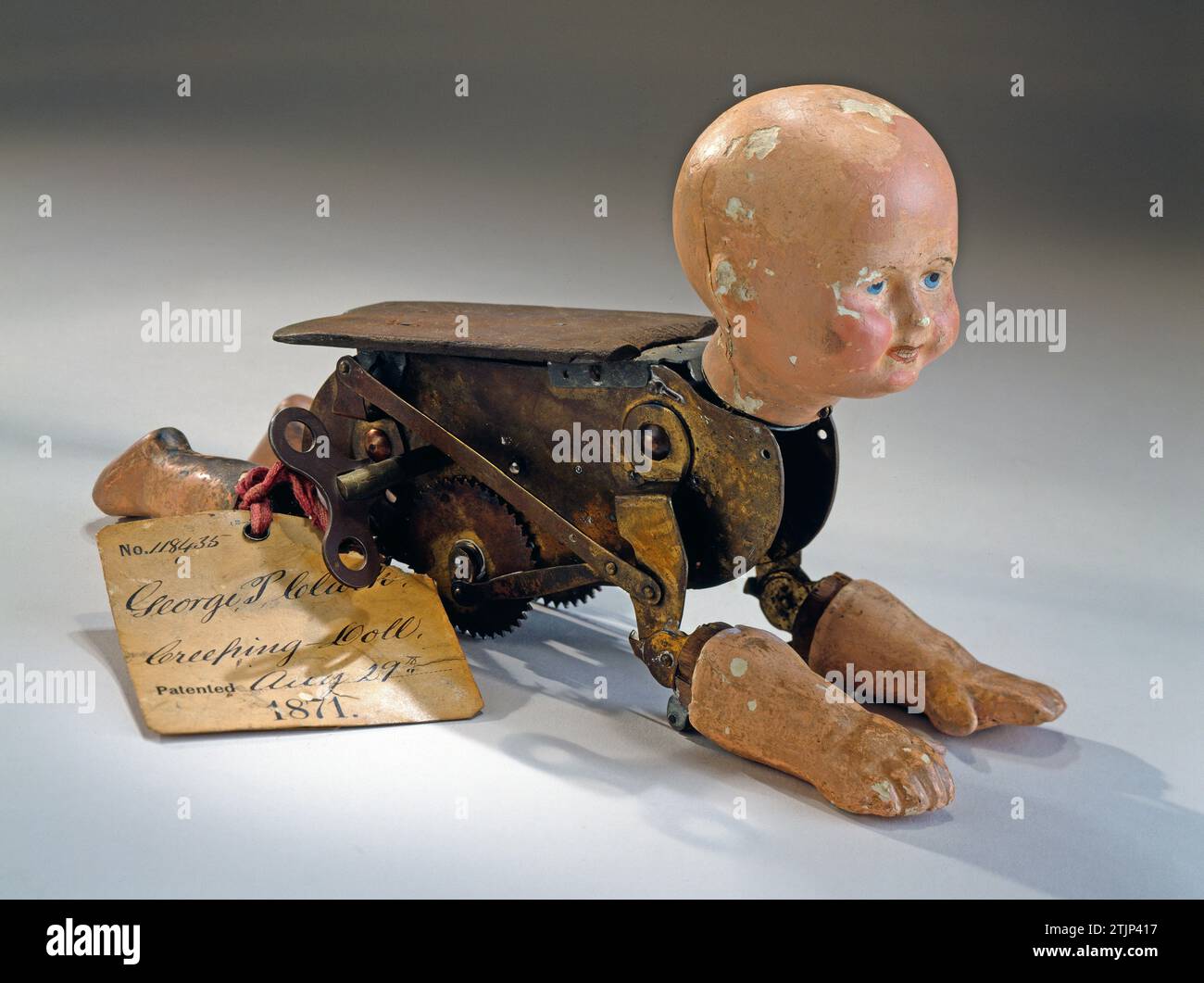 Mechanical creeping baby doll, 1871, patent no.118435, invented by George P. Clarke.This model demonstrates the invention of a mechanical crawling doll, receiving U.S. patent No. 118435 on 29 August 1871 for his ÒNatural Creeping Baby Doll.Ó The original patent office tag is still attached with red tape. Clarke's patent was an improvement on the crawling baby doll patent of his associate Robert J. Clay (No. 112550 granted 14 March 1871).  Optimised version of an image of an object in the Smithsonian American Art Museum, Washington DC, USA. Stock Photo