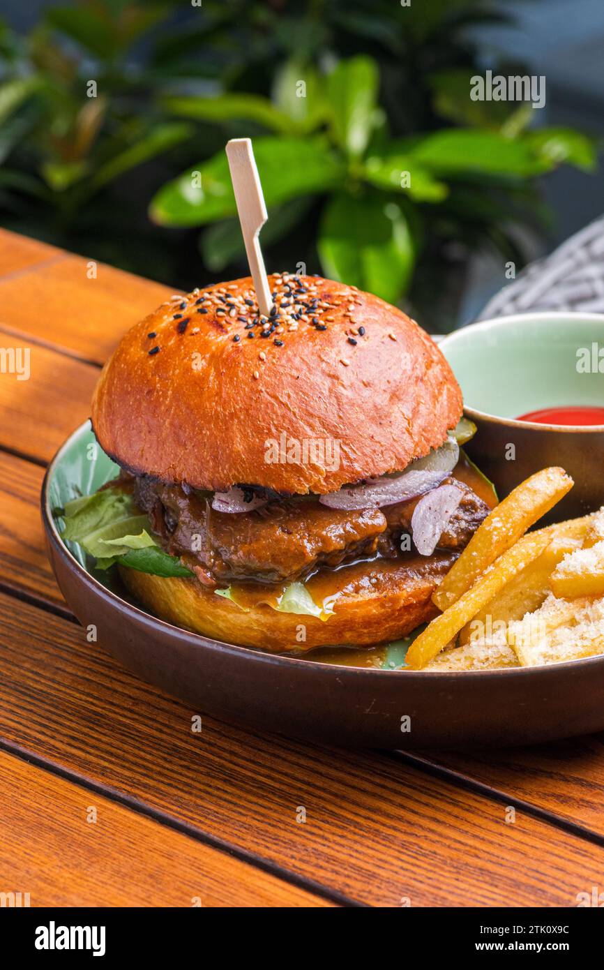 Burger with veal cheeks, cheese and vegetables. Fast food. Free space ...