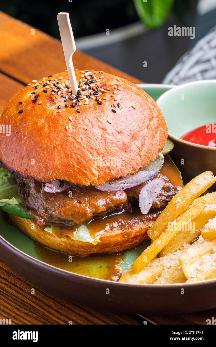 Burger with veal cheeks, cheese and vegetables. Fast food. Free space ...
