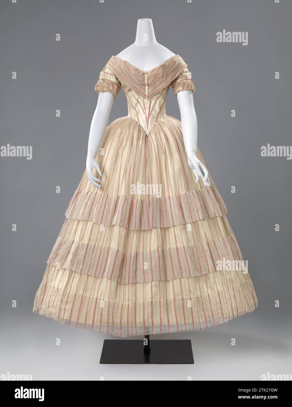 Full Evening Dress, anonymous, c. 1850 - c. 1856 Girl's dress of white Tarlatan with pink stripes. The low -cut body has short sleeves and ends pointy from the front over the skirt, to which it is sewn. The spacious skirt is unlined, has two wide ramps and a wide zoom. I.v.m. Exhibition was made of the crème satin in 1996 (A-1) at the dress in 1996. Netherlands tarlatan. cotton (textile). satin. silk. metal Girl's dress of white Tarlatan with pink stripes. The low -cut body has short sleeves and ends pointy from the front over the skirt, to which it is sewn. The spacious skirt is unlined, has Stock Photo