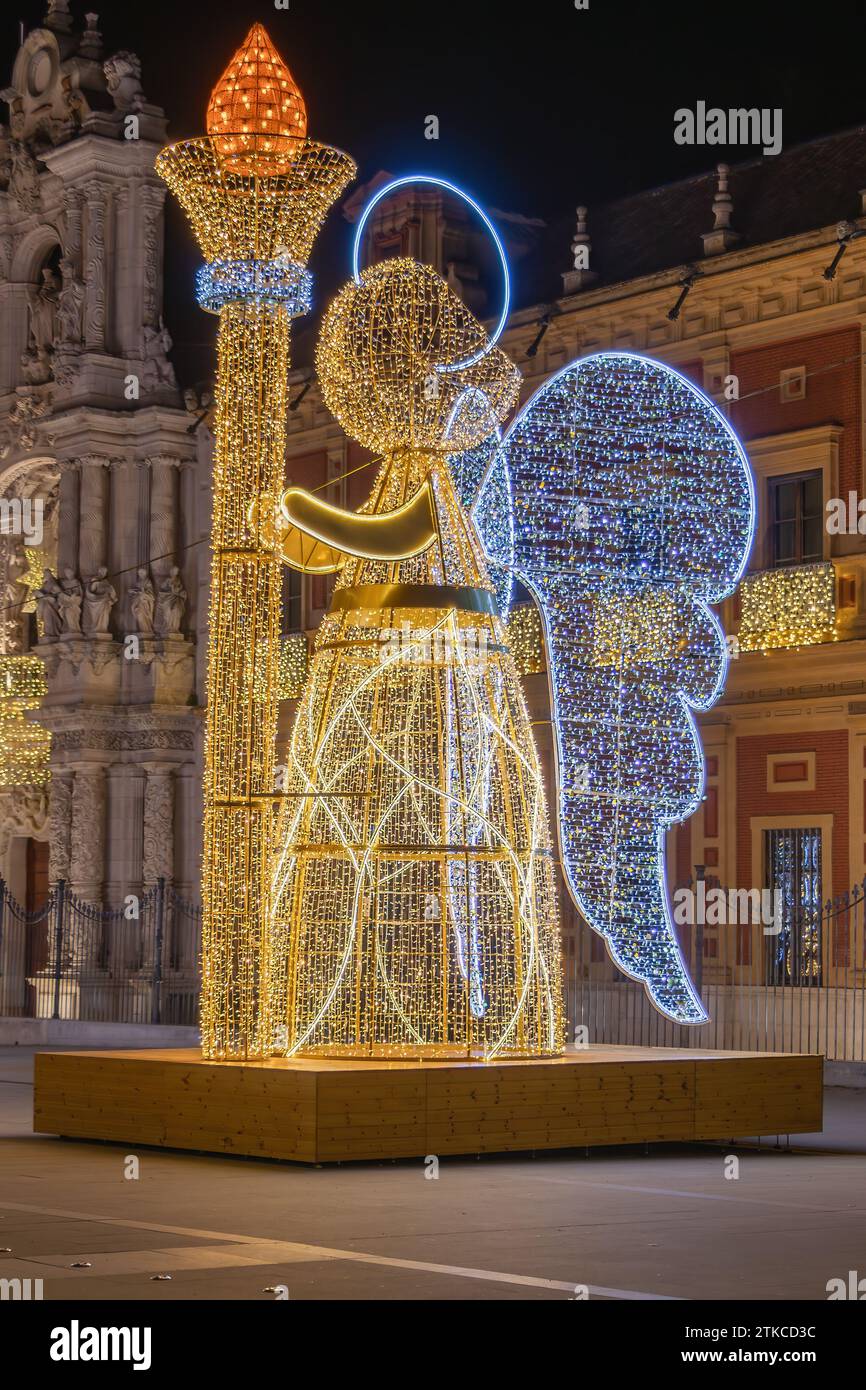 Christmas lights decoration in the shape of an angel holding a torch in from of The Palace of San Telmo, In Seville, Andalusia, Spain, at Christmas ti Stock Photo