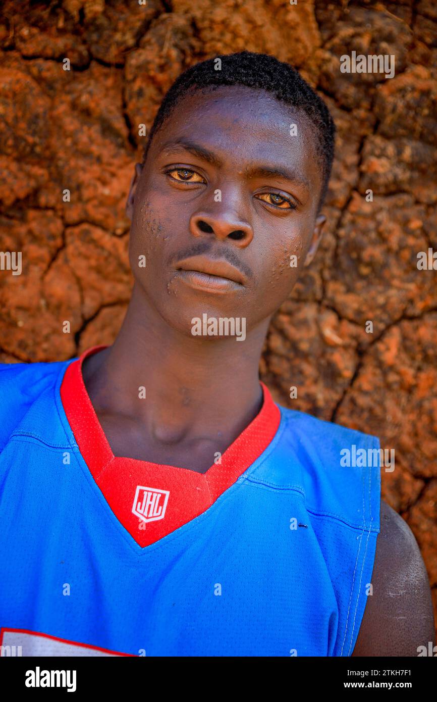 A young man is posed for a photo by the streets of Kibera Slum in ...