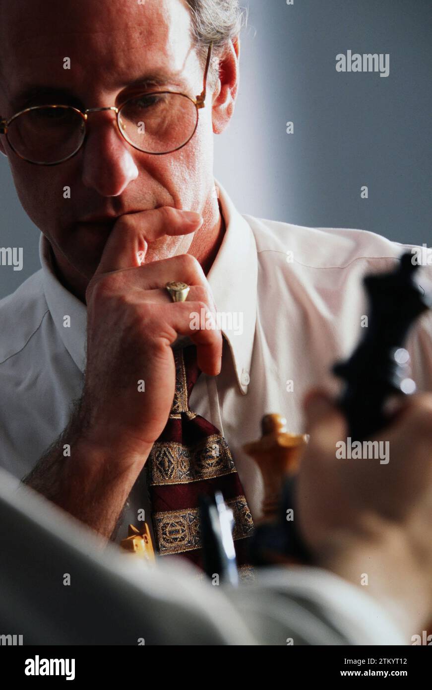 Businessman concentrating on a chess move while contemplating a chess move Stock Photo