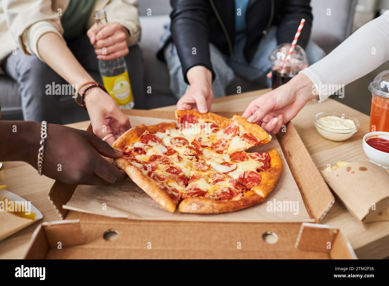 Friends Sharing Pizza at Home Stock Photo