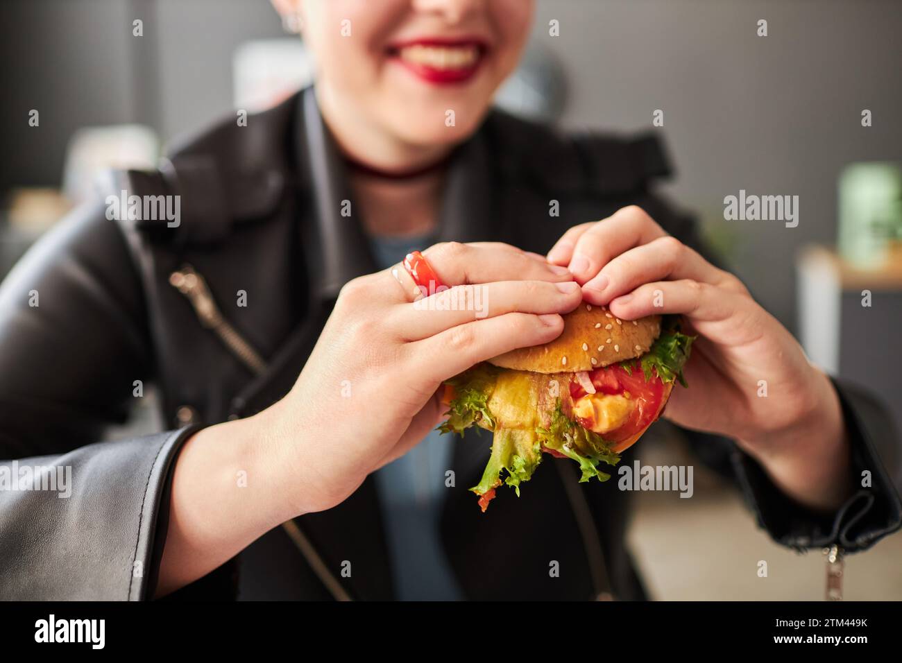 Smiling Girl Holding Burger Stock Photo