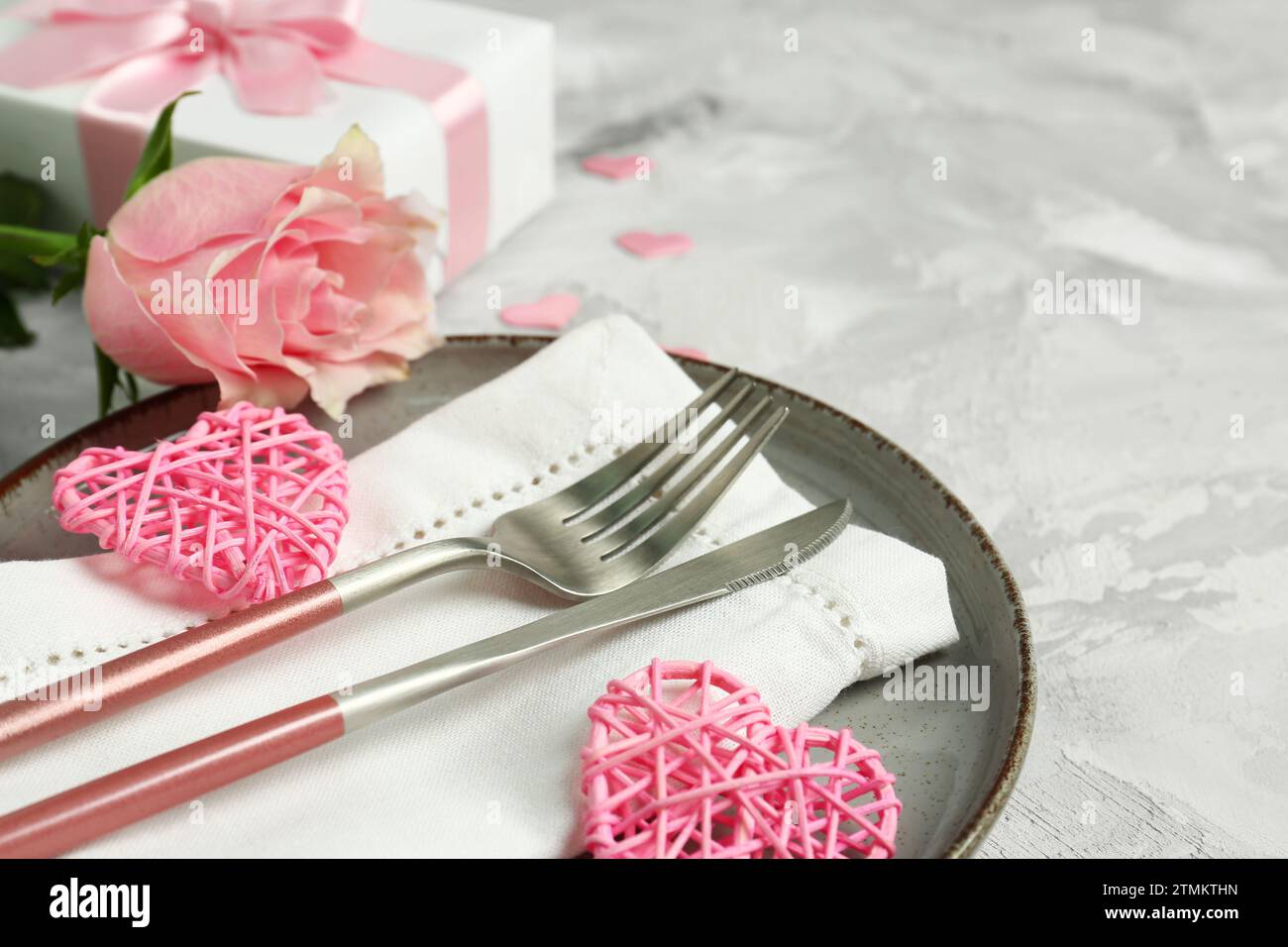 Beautiful table setting for Valentine's Day with pink rose, gift and ...