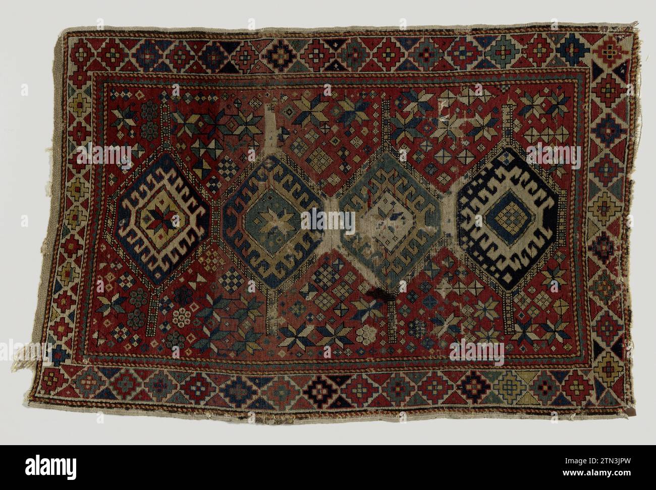 Carpet, kazak, with medallion pattern ,, c. 1800 - c. 1900 Carpet, Kazak, with medallion pattern. Midfield: on a red stock that is strewn with stars and blocks, there are four hexagonal medallions in the length axis, two of ultramarine, one of cobalt blue and one of light green with window and hooks. Edges: A white stock is divided by lateral triangles in red, ultramarine, yellow, orange and green in diamond fields, on which angular rosettes are. Inner zoom from interlocking triangles of red and green. State: entered with moths, larvae, etc. Cleaned in the snow. With large ink stain. Holes in Stock Photo
