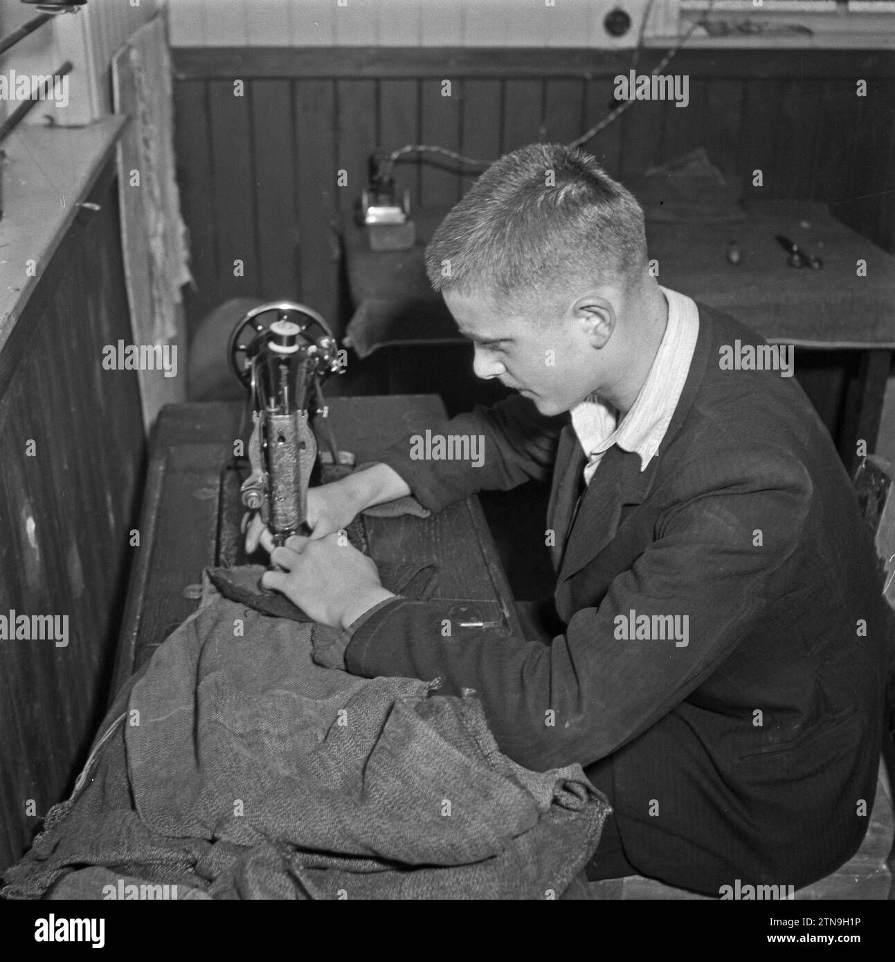 Boy behind a sewing machine ca. October 1945 Stock Photo - Alamy