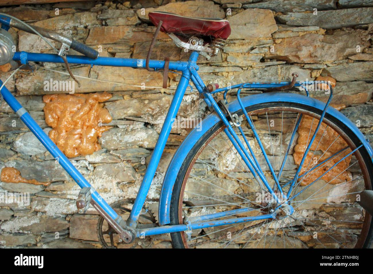 Rustic Charm: Antique Bike Suspended on Stone Backdrop Stock Photo