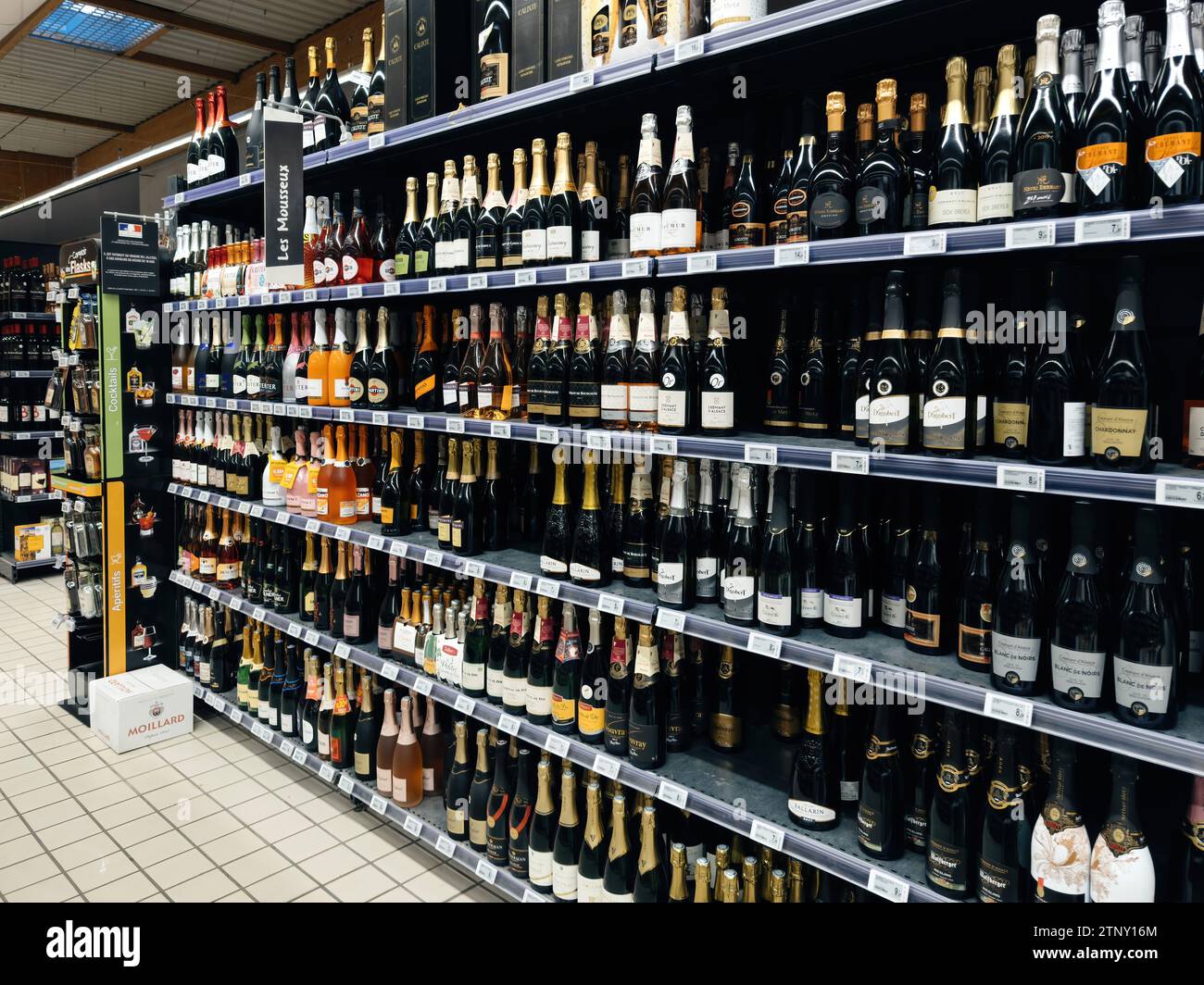 Paris, France - Nov 10, 2023: Side view of holiday-ready shelves in a supermarket, stocked with a range of champagne, prosecco, and cremant, from budg Stock Photo