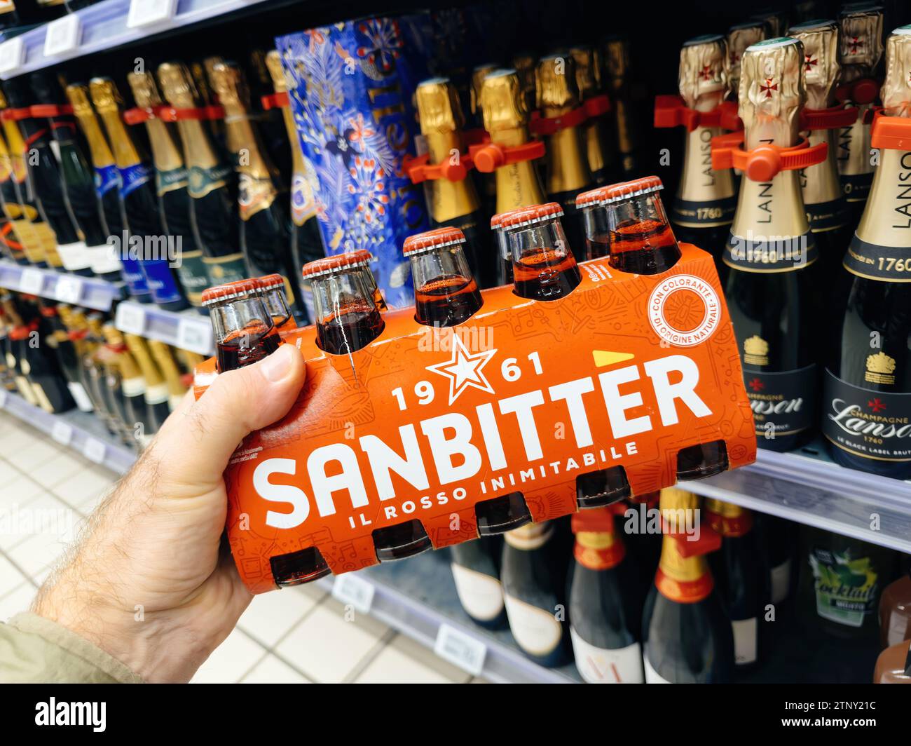 Paris, France - Nov 10, 2023: A male hand delicately holds a package of Sanbitter 1961 Il Rosso, the inimitable digestive, in a French supermarket Stock Photo