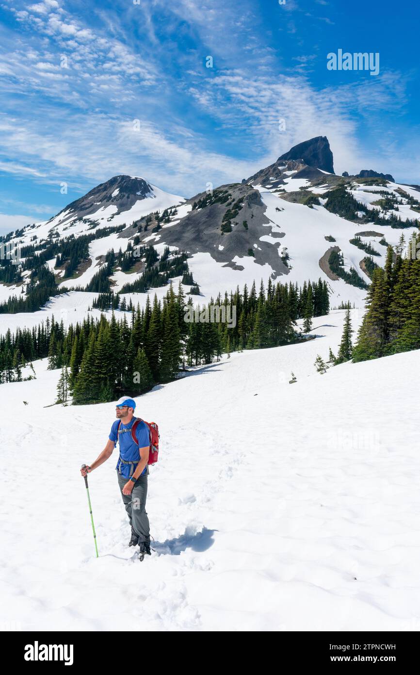Hiker advances on Panorama Ridge with the towering Black Tusk in the distance Stock Photo