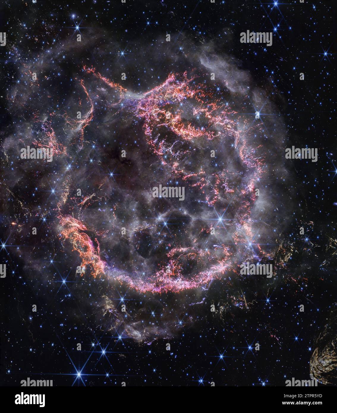 This image, released on December 10, 2023, and taken by NASA's James Webb Space Telescope's NIRCam (Near-Infrared Camera), unveils intricate details of supernova remnant Cassiopeia A (Cas A) and shows the expanding shell of material slamming into the gas shed by the star before it exploded. The most noticeable colors in Webb's newest image are clumps of bright orange and light pink that make up the inner shell of the supernova remnant. These tiny knots of gas, comprised of sulfur, oxygen, argon, and neon from the star itself, are only detectable by NIRCam's exquisite resolution and give resear Stock Photo