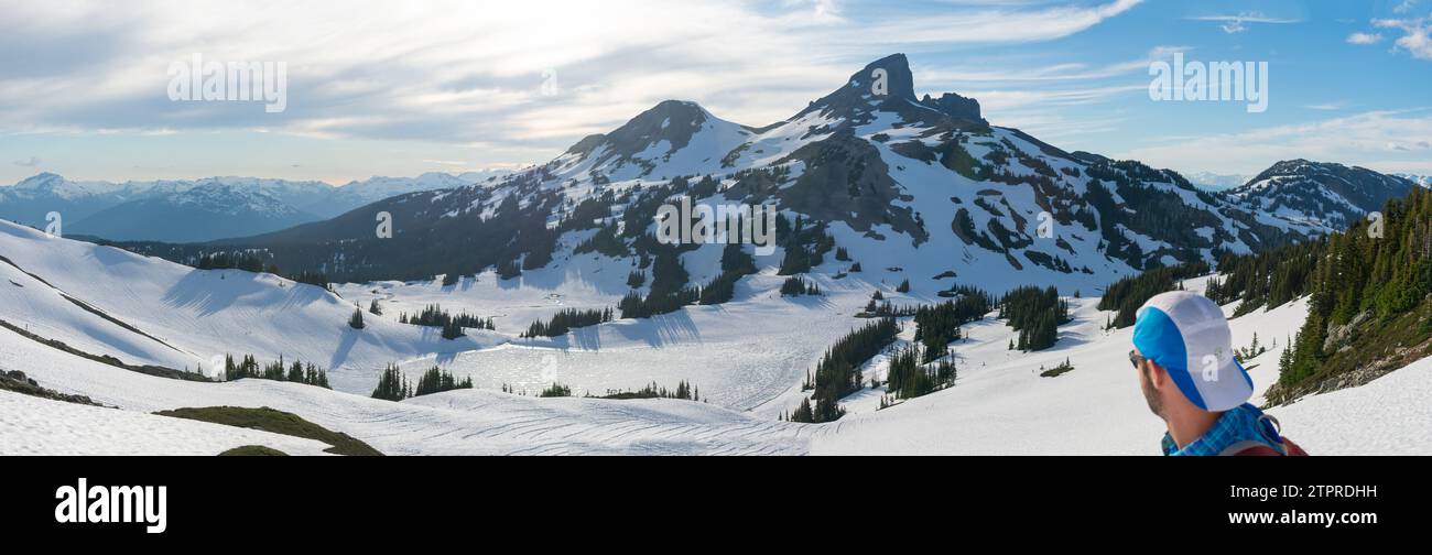Hiker on Panorama Ridge observing the iconic Black Tusk in spring. Stock Photo
