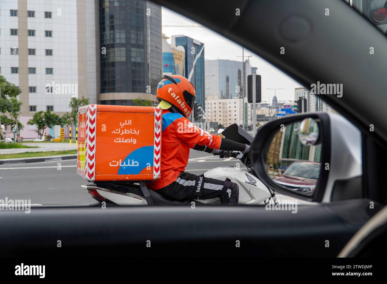 Delivery boy Talabat food Delivery rider on Doha road Stock Photo
