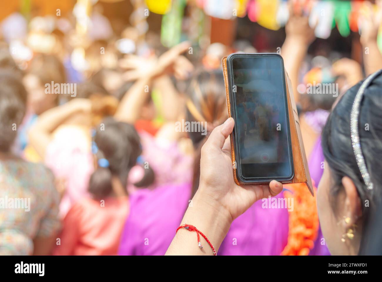 Hand women holding smart phone mobile shooting burmese people dress in national costumes, Come out to participate and dance in the Kathin festival dur Stock Photo