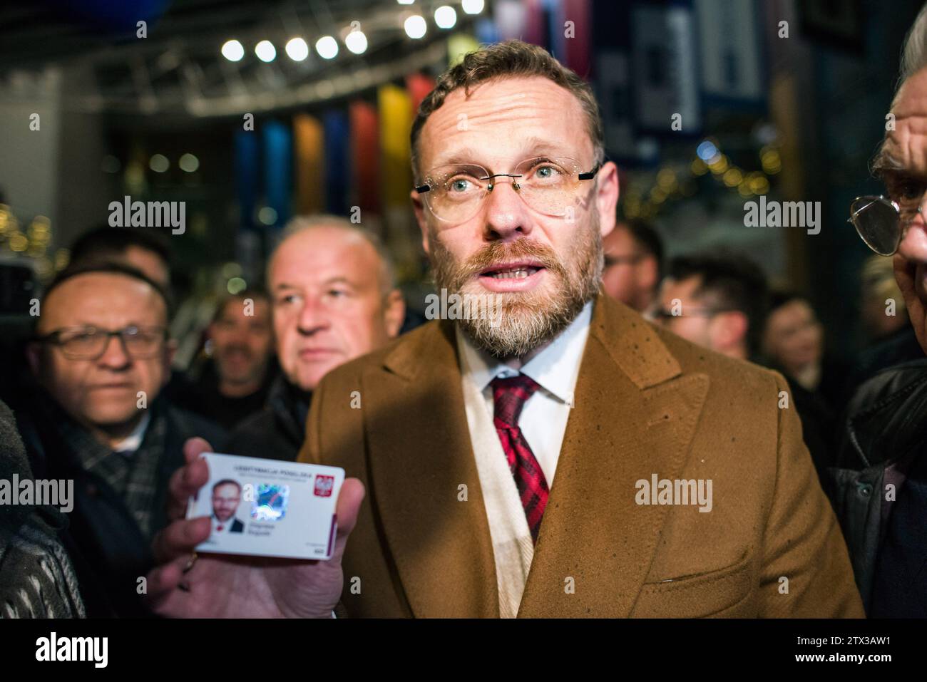 Zbigniew Bogucki, a member of the Law and Justice party (PiS) shows his parliamentary ID card as he wants to be let into the headquarters of TVP state TV during a sit-in protest. Poland's new pro-European Union government said Wednesday that it had changed the directors of state television in Poland known as TVP, radio and the government-run news agency as it embarked on the path of freeing publicly-owned media from the political control of the previous nationalist conservative administration. The Cabinet of Prime Minister Donald Tusk, which took office last week, has made it a priority to res Stock Photo