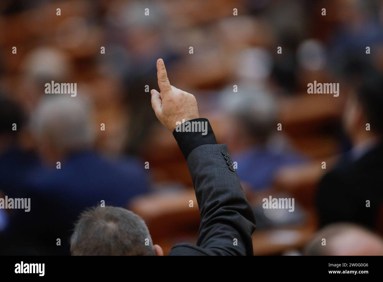 Bucharest, Romania - December 20, 2023: Member of parliament gestures to his colleagues how to vote on bills. Stock Photo