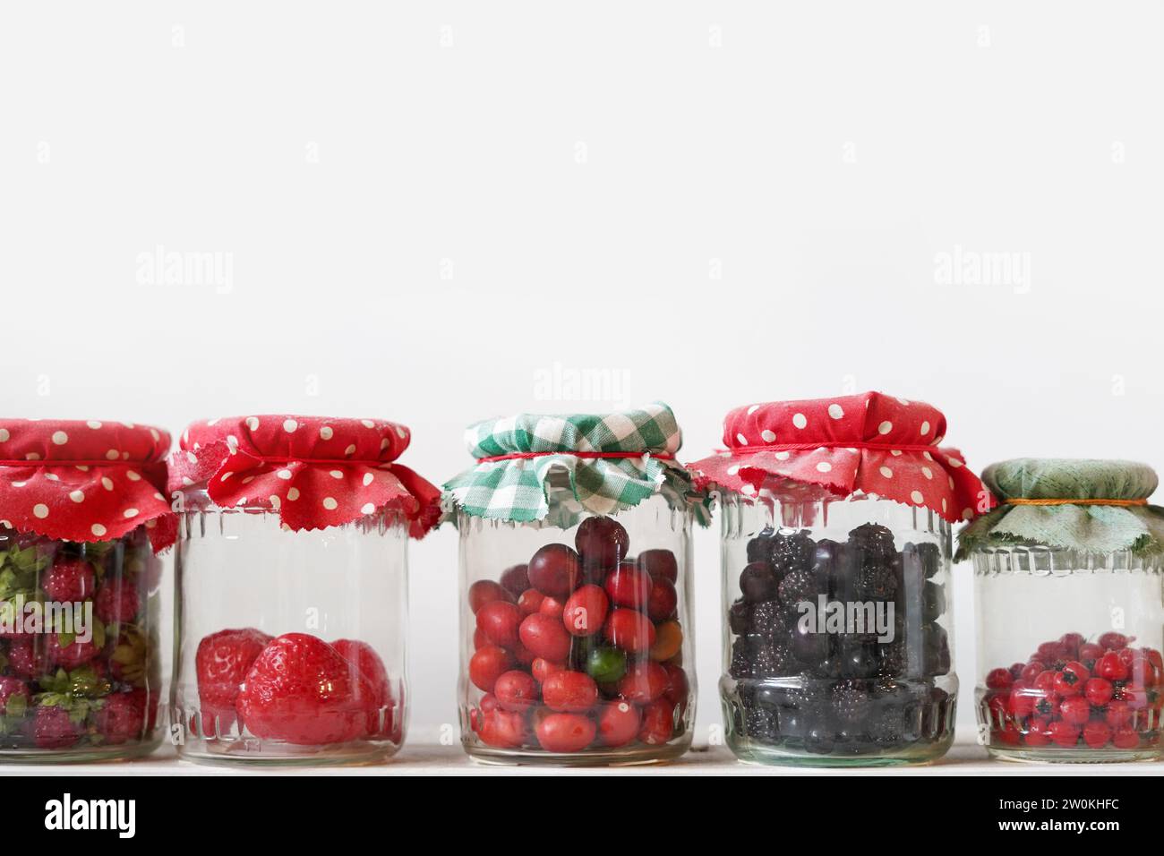 storing food vegetables, fruits in glass jars, white background, copy