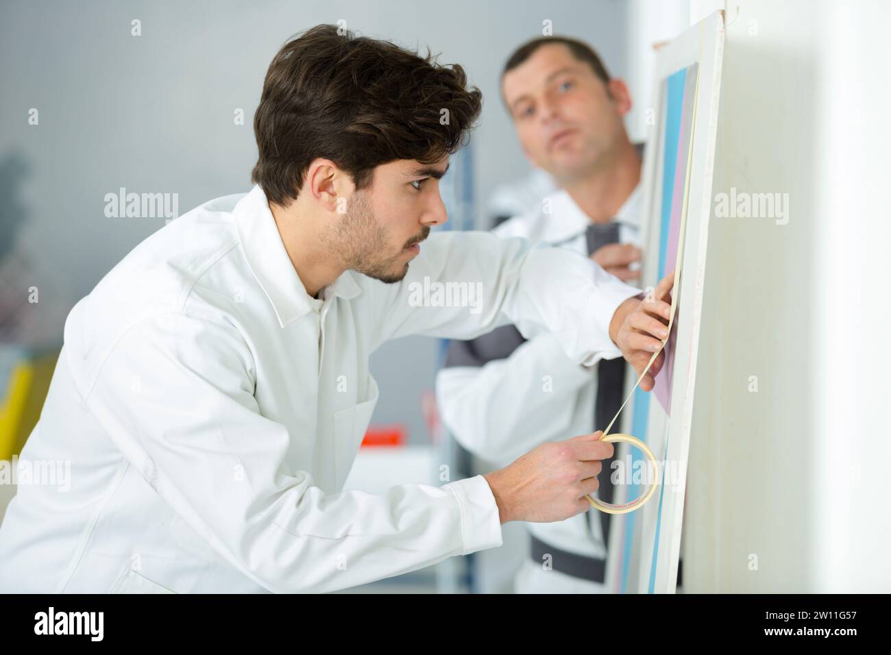 Apprentice Painter And Decorator Using Masking Tape Stock Photo Alamy
