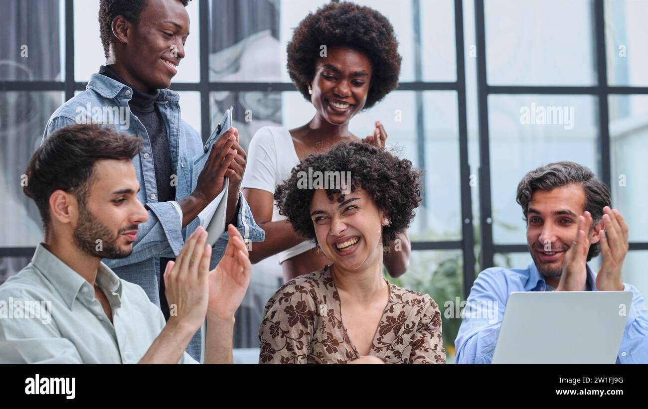 Employees working at computer together, discussing content Stock Photo