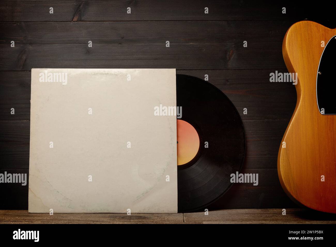 Blank cardboard record sleeve and a guitar on wood wall Stock Photo Alamy