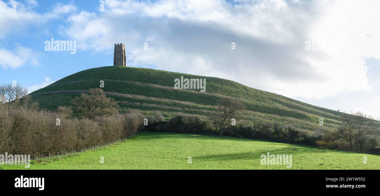 Glastonbury Tor in Somerset UK showing terraced lynchets along its slopes and crowned by the isolated tower of St Michael's church Stock Photo