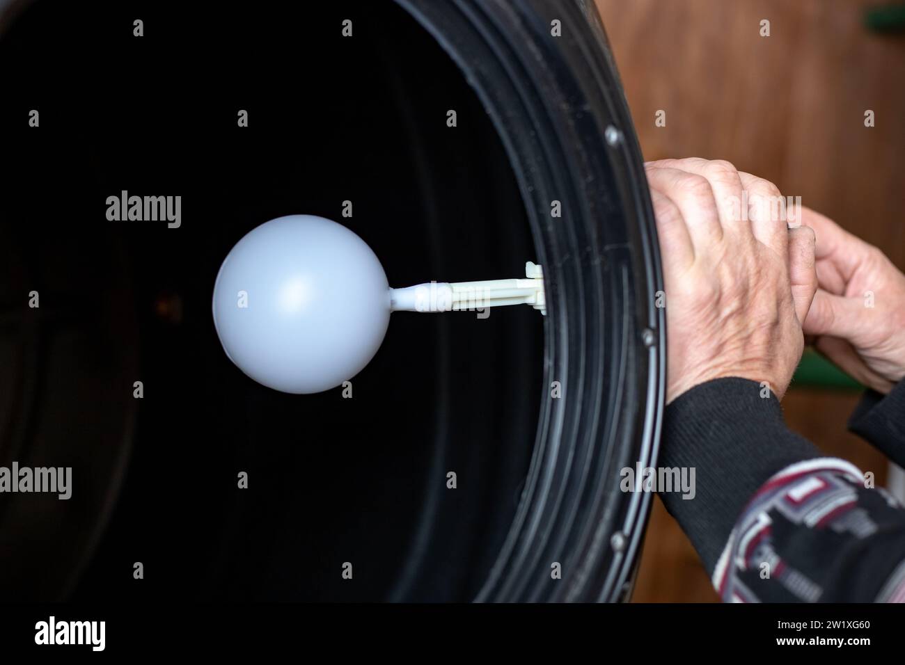 plumber inserts a valve with a float into the water tank to restrict