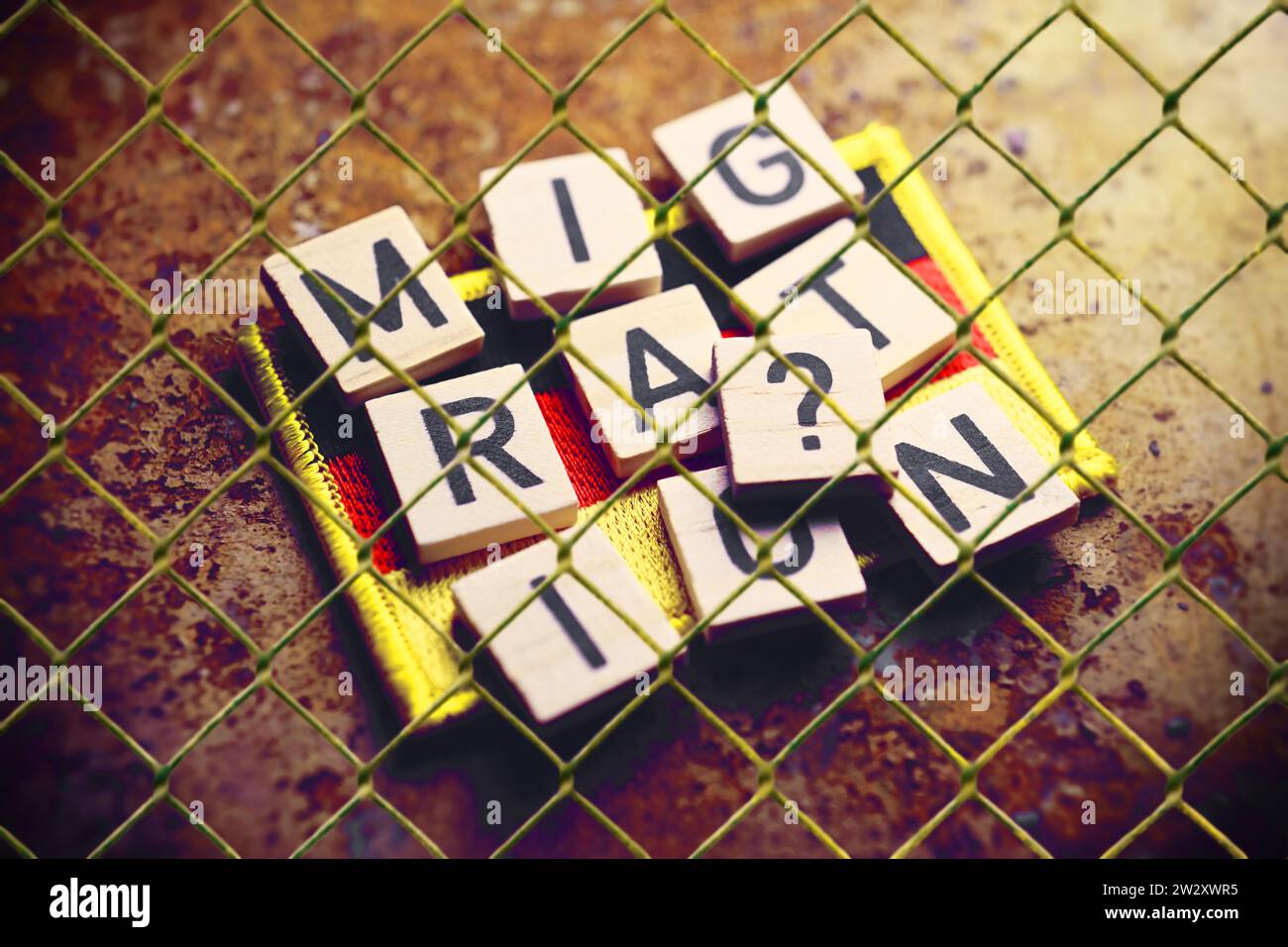 FOTOMONTAGE, Schriftzug Migration und Fragezeichen auf Fahne von Deutschland hinter einem Gitter, Symbolfoto Migrationskrise Stock Photo