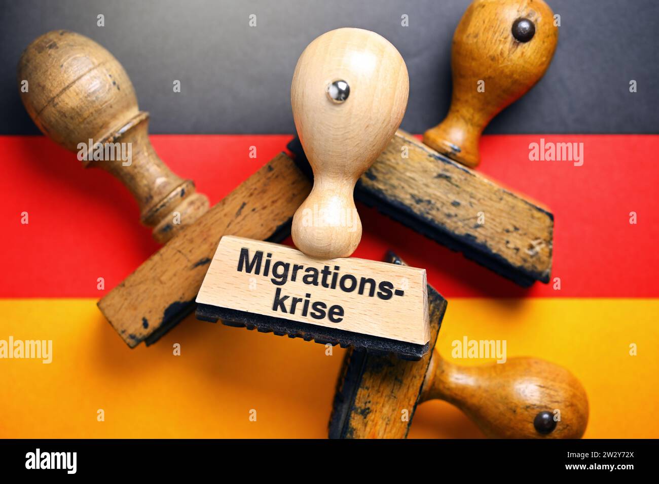 FOTOMONTAGE, Stempel mit Aufschrift Migrationskrise auf deutscher Fahne Stock Photo