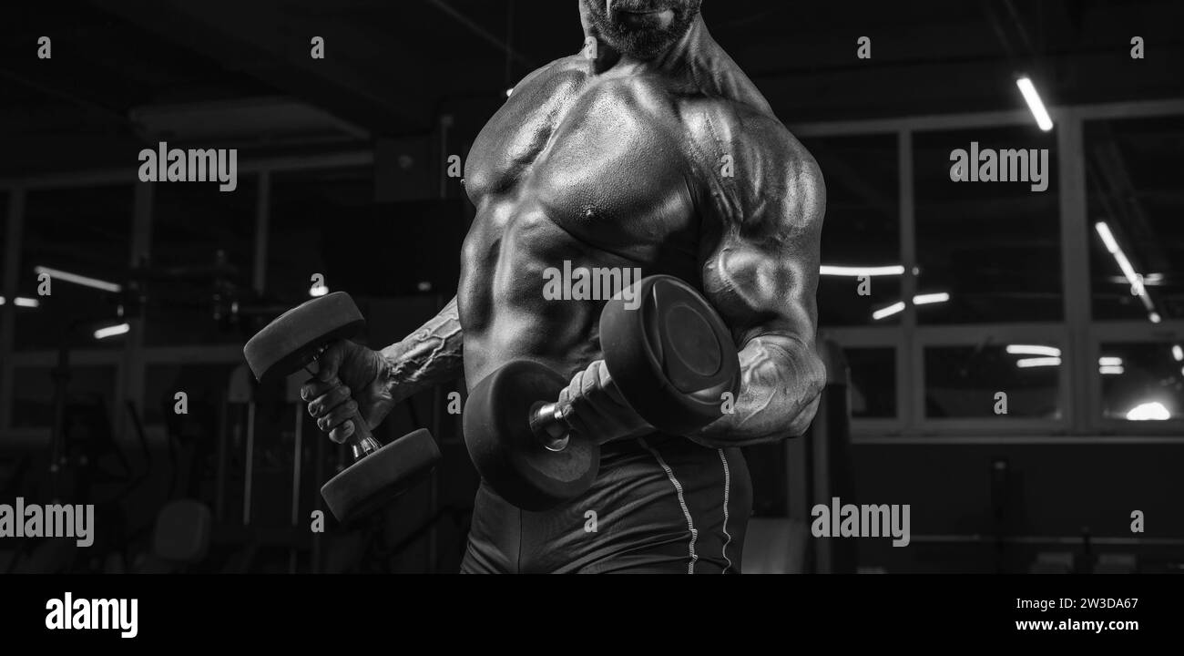 Noname image of a powerful athlete pumping biceps with dumbbells in the