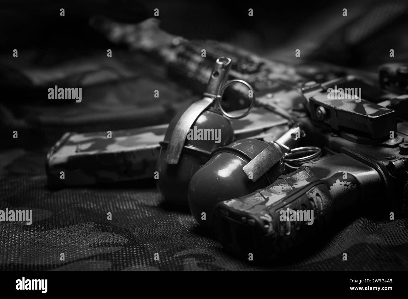 Two grenades lie on a camouflage background. The concept of military operations, political conflicts, armed forces. Top view. Mixed media Stock Photo