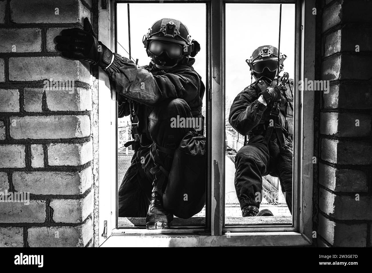 Group of special forces fighters storm the building through the window. Training sessions of the SWAT team. Anti-terror concept. Climbers. Mixed media Stock Photo