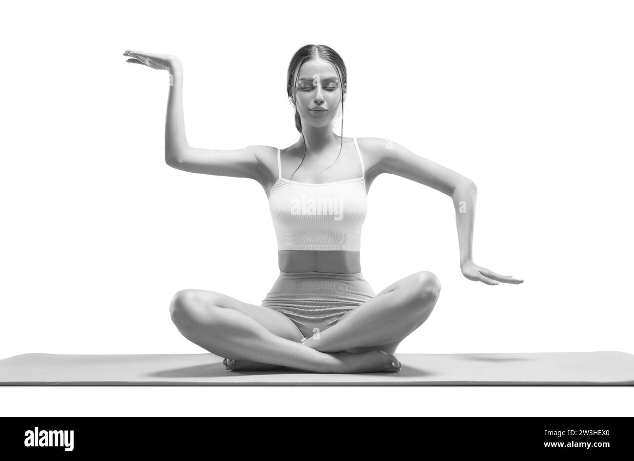Sporty young woman doing yoga practice. Isolated on a white background. The concept of a healthy lifestyle and natural balance between body and Stock Photo