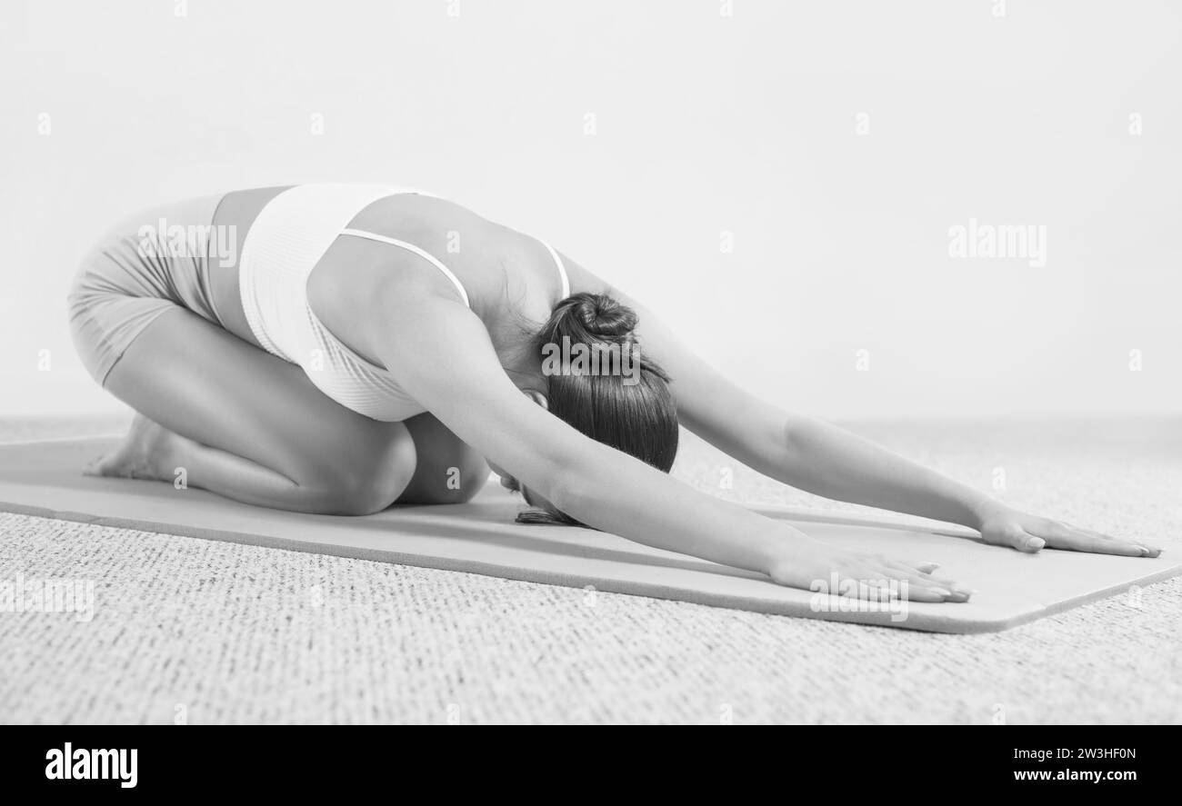 Sporty young woman doing yoga practice. Isolated on a white background ...