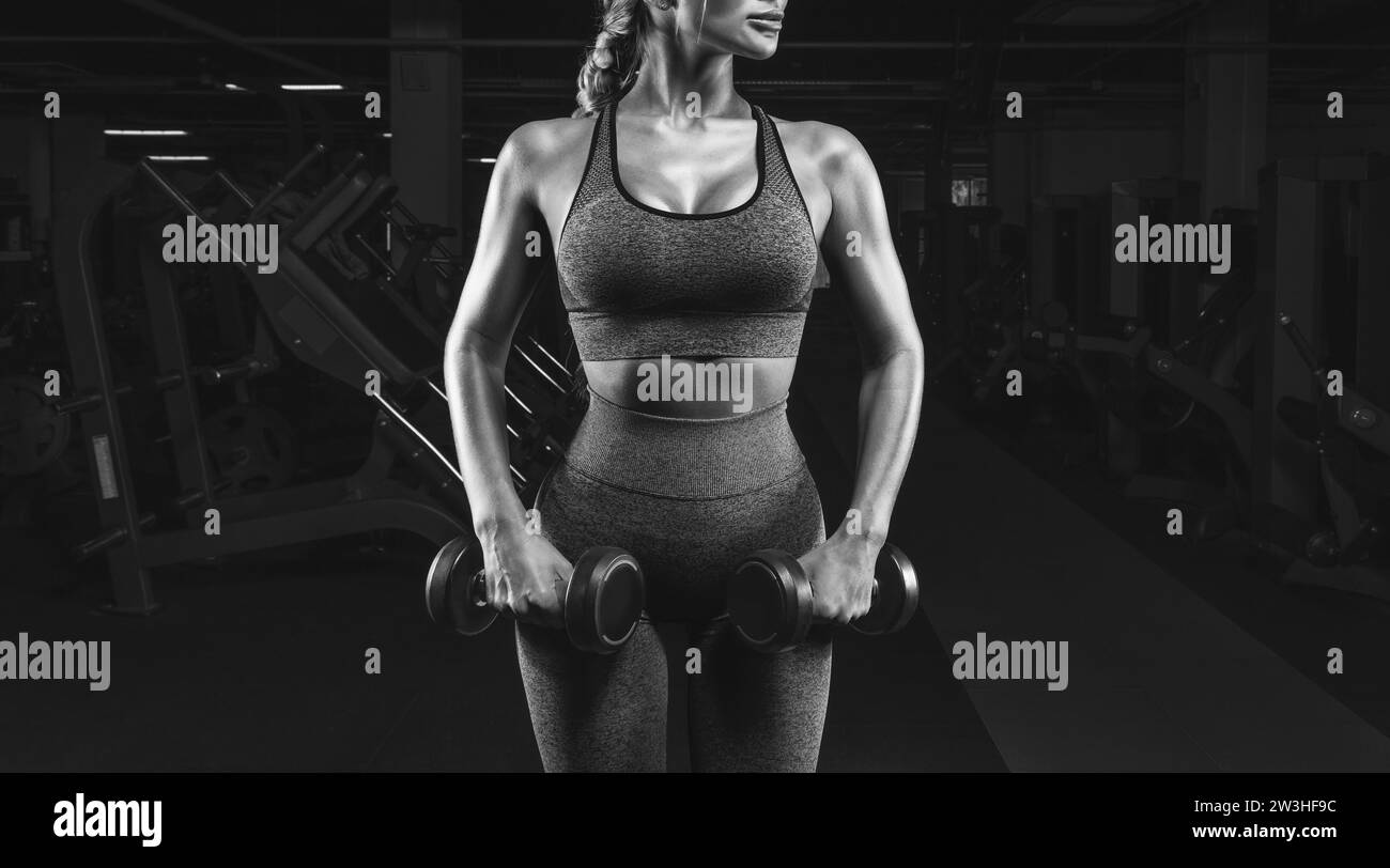 Athletic girl in pink sports uniform works out in the gym. Fitness