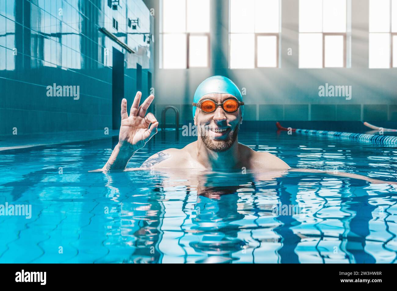 Portrait of a man in the pool. He is wearing huge funny glasses. Water sports concept. Mixed media Stock Photo