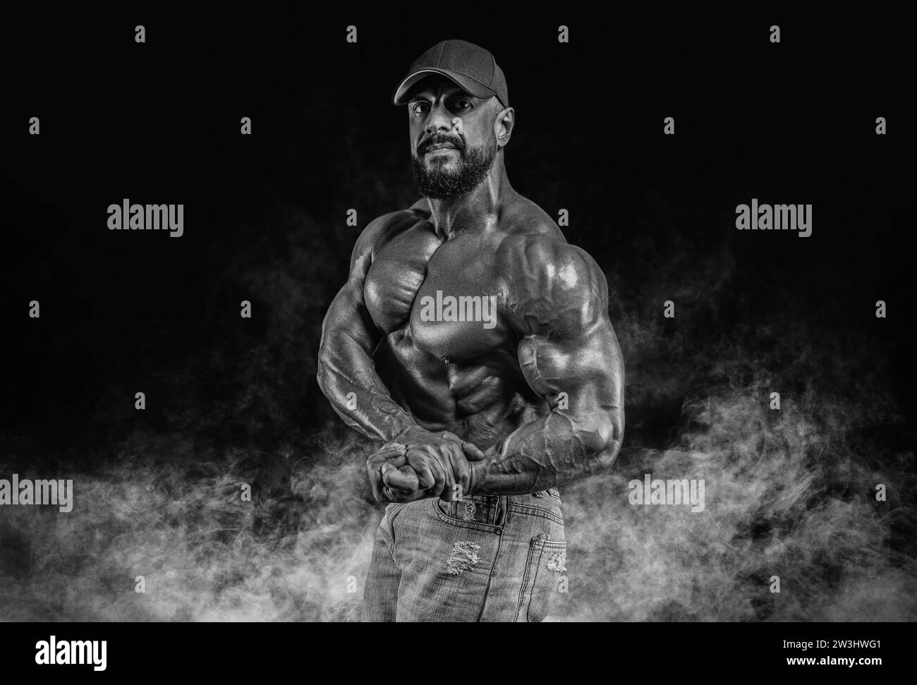 Muscular athlete posing in the studio. Fitness and classic bodybuilding concept. Mixed media Stock Photo
