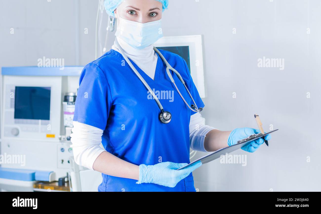 Portrait of a woman in a blue medical suit, mask and cap. Medicine ...