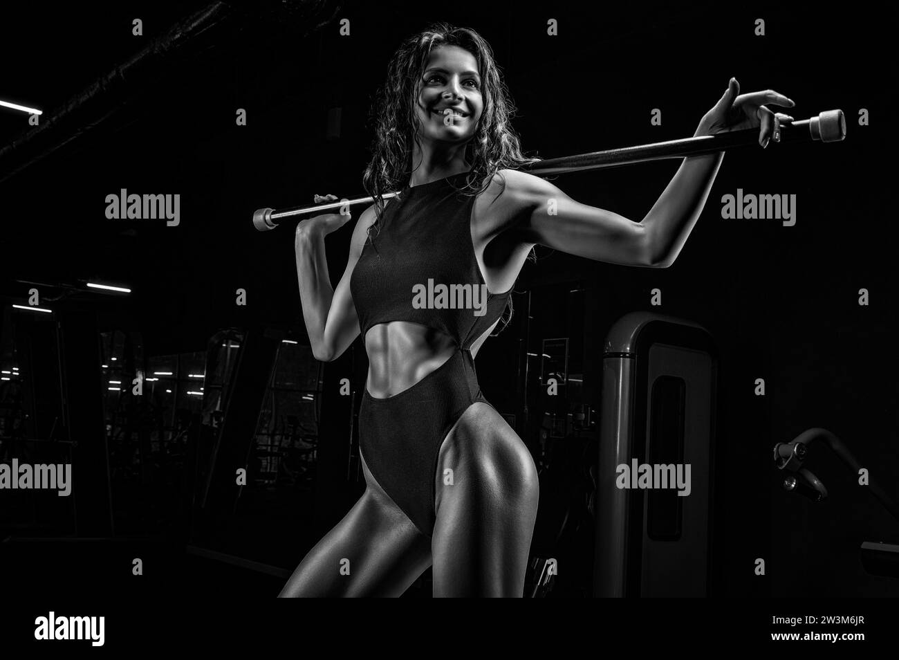Charming girl posing with a bodybar. The concept of fitness, bodybuilding and healthy lifestyle. Mixed media Stock Photo