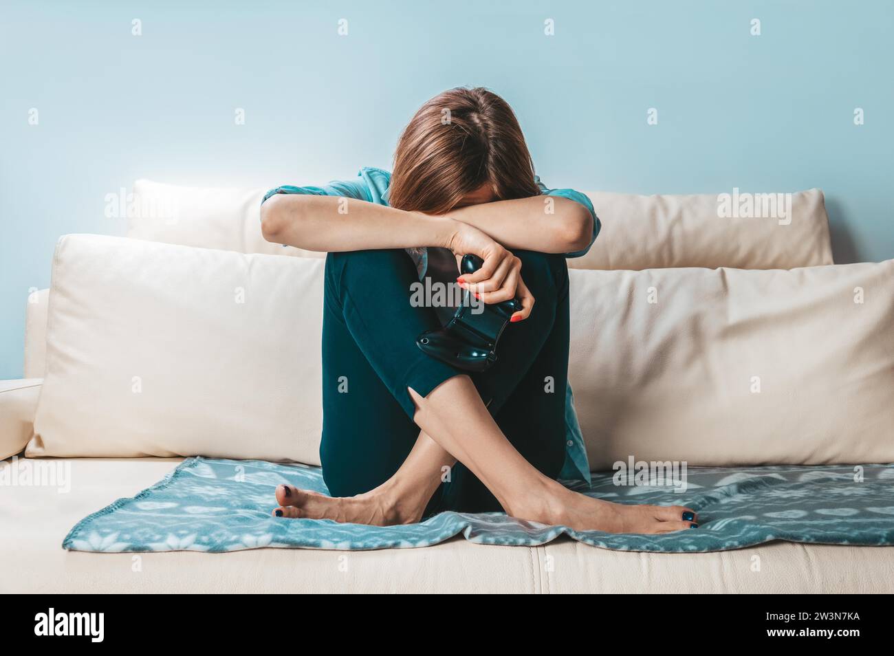 Girl with a joystick in her hands cries because of a defeat in the game. ESports concept. Mixed media Stock Photo