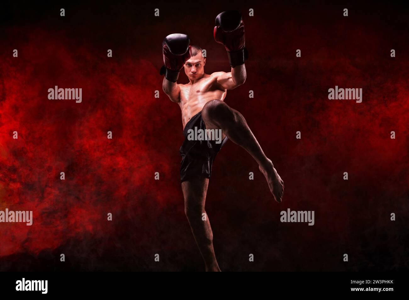 Professional kickboxer posing against a background of fire and smoke