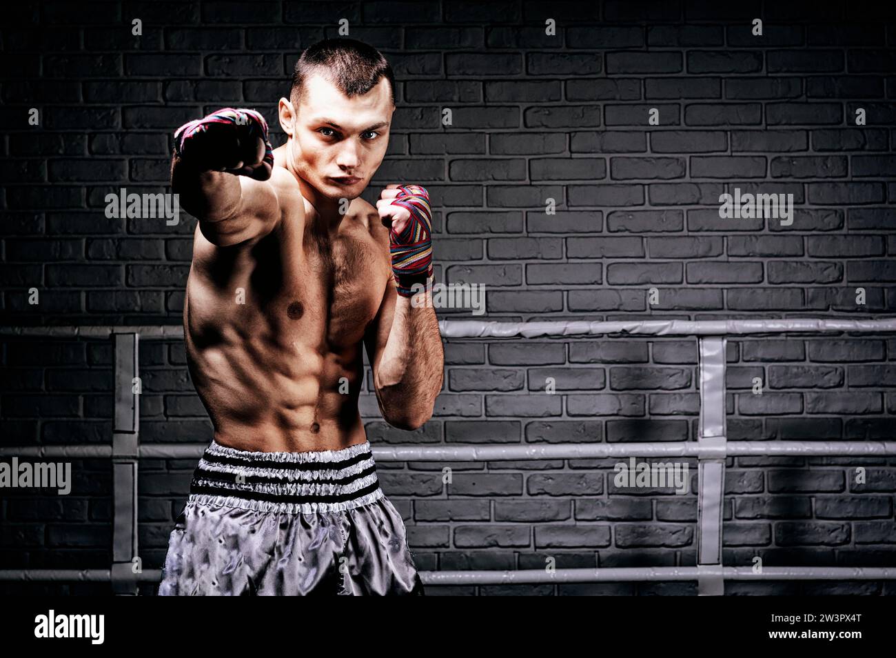 Thai boxer stands in the ring and punches in front of him. The concept