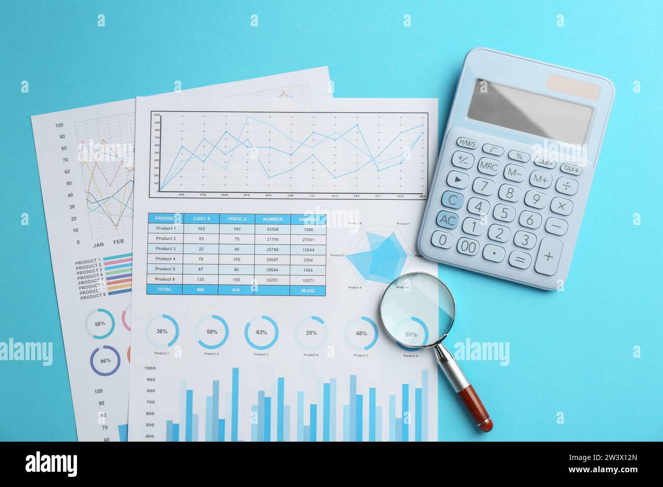 Accounting documents, magnifying glass and calculator on light blue ...