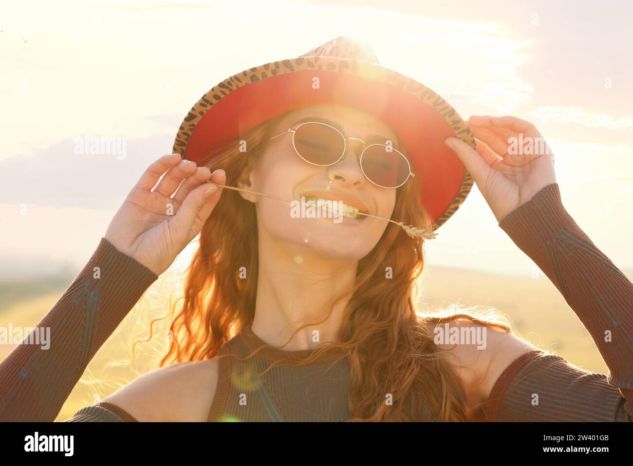 Beautiful happy hippie woman with spikelet in field Stock Photo