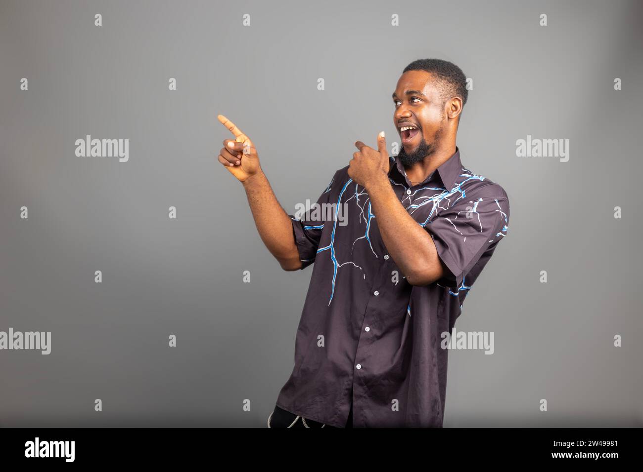 Overexcited young black guy raising fist up on white background ...