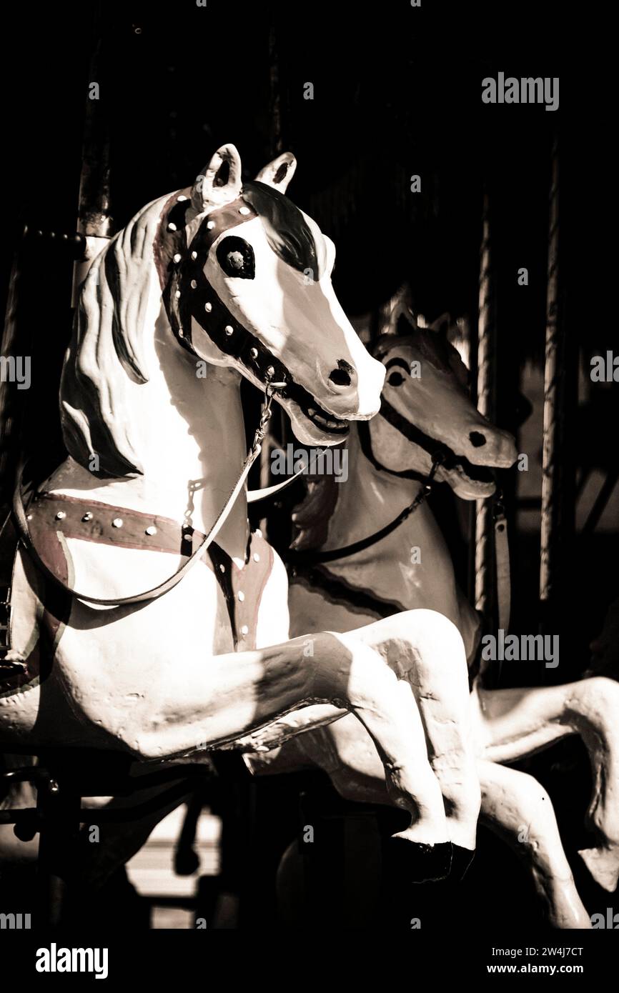 Vintage carousel horses in a darkened amusement park captured during a ...