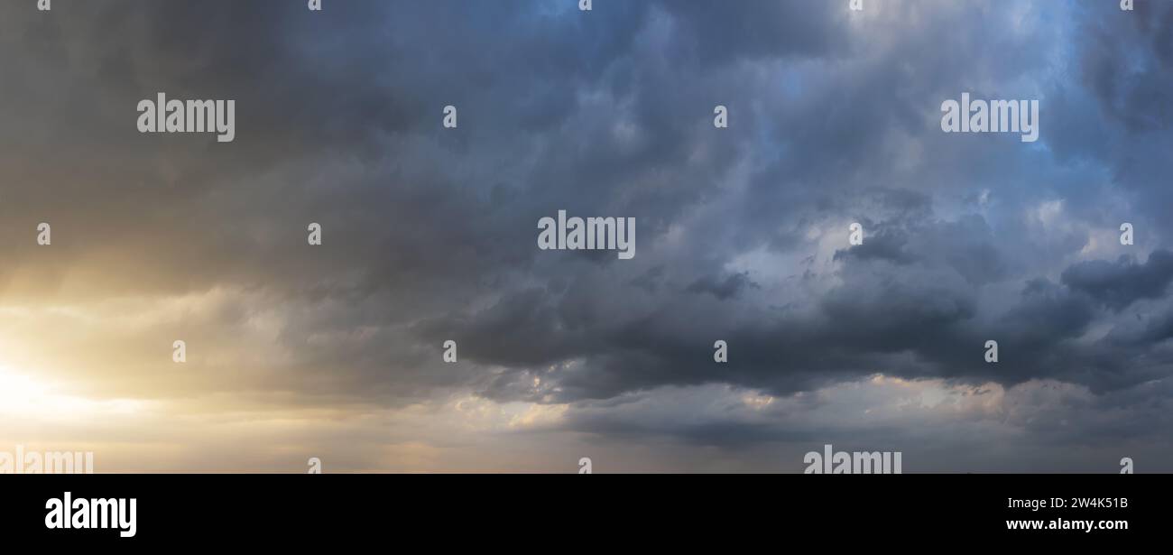 Dramatic sunset sky with dark rainy clouds. Nature background. Sky panorama. Stock Photo