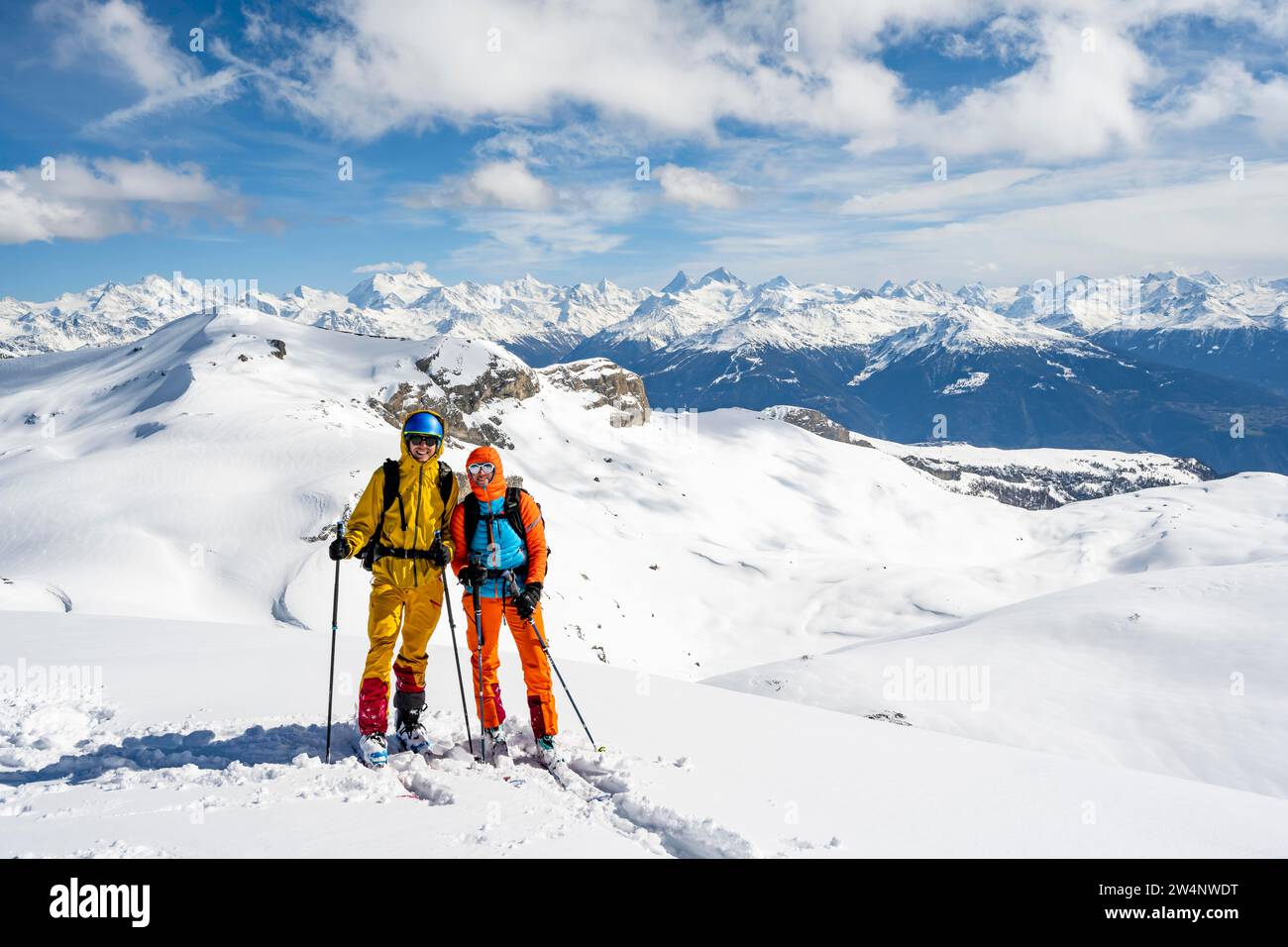 Two ski tourers at the summit of the Wisshore, picturesque mountain panorama of the Valais mountains, Bernese Alps, Switzerland Stock Photo